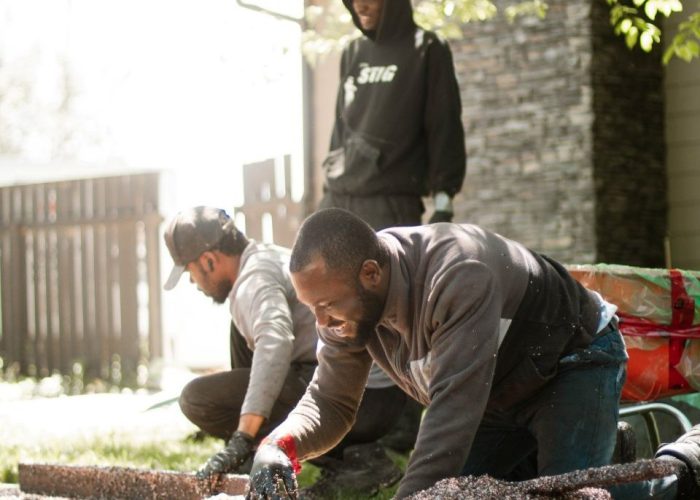 Paving crew putting down rubber paving in Lethbridge backyard